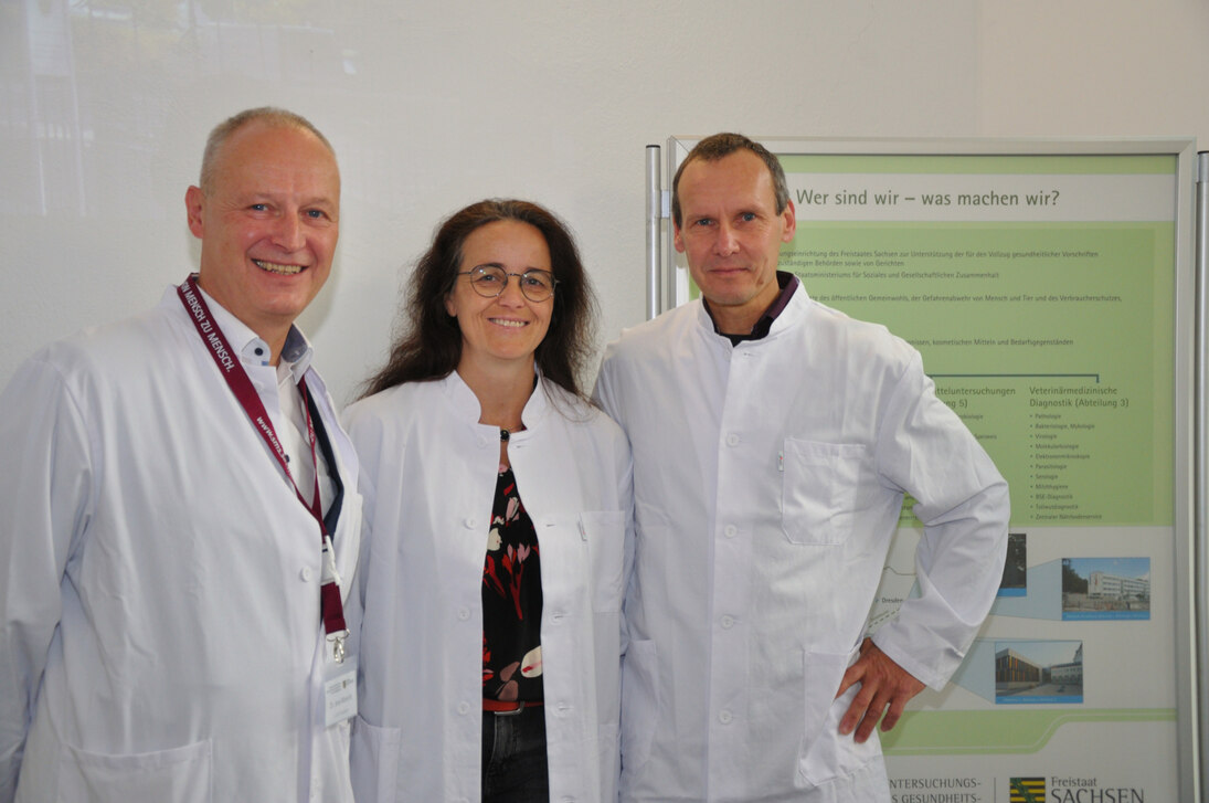 Foto von Herr Dr. Albrecht, Frau Staatssekretärin Neukirch, Herr Dr. Helling vor einem Plakat der LUA